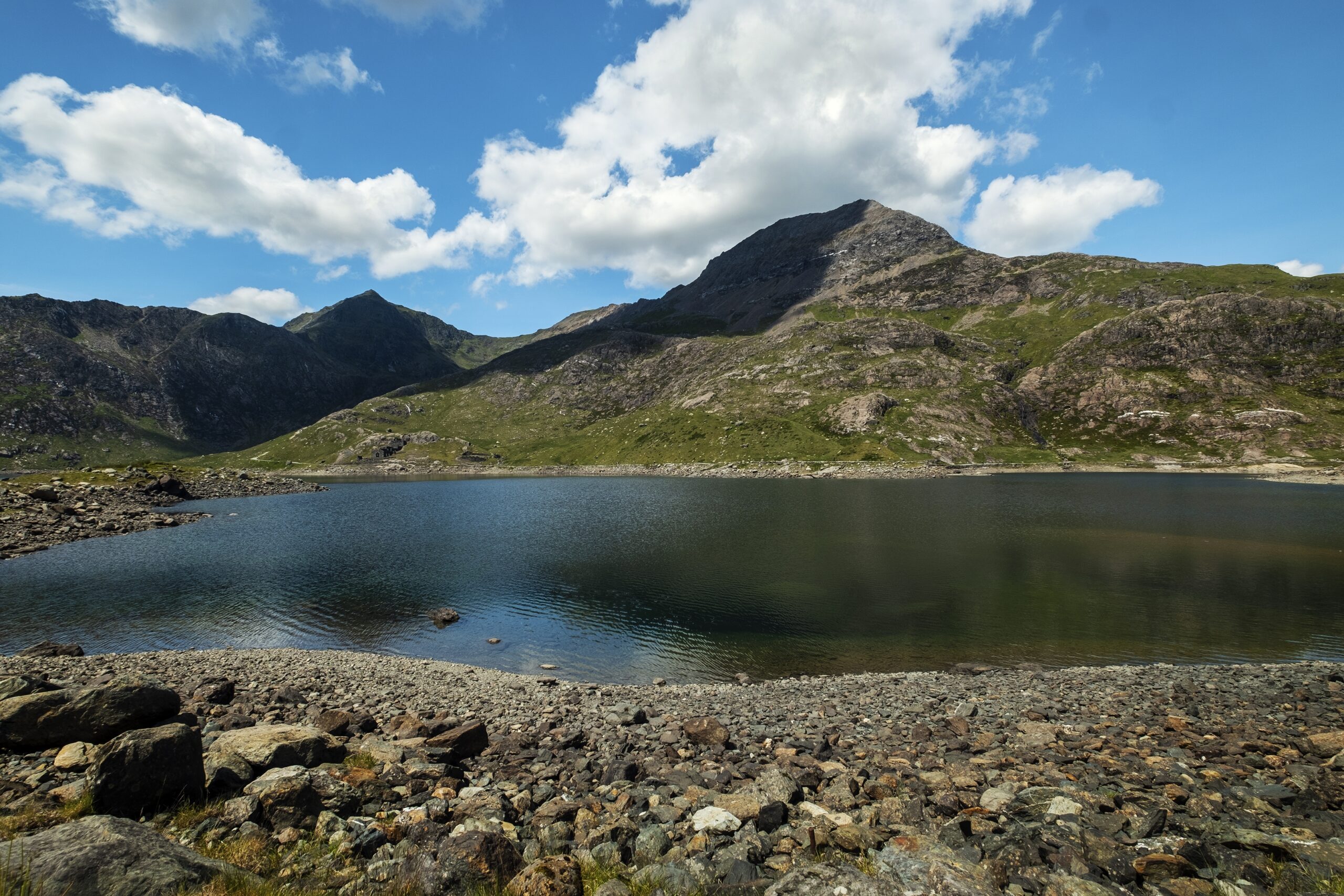 A beautiful view of a mountain and a calm lake with a cloudy sky